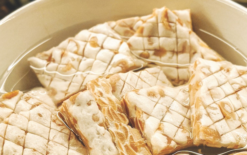You can soak tempeh in a flavoured brine before cooking