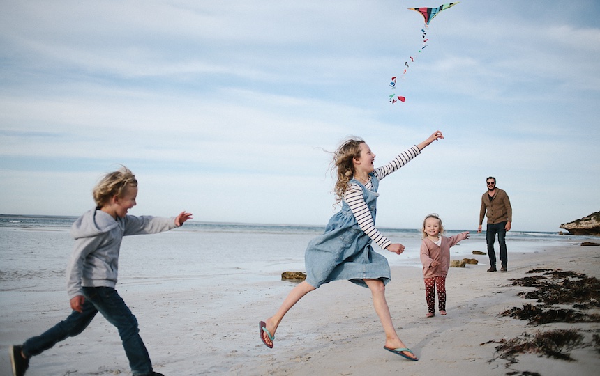 kids flying a kite on the beach